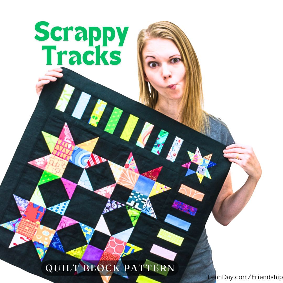 Leah Day holding a colorful Scrappy Tracks quilt block from the Friendship Sampler Quilt