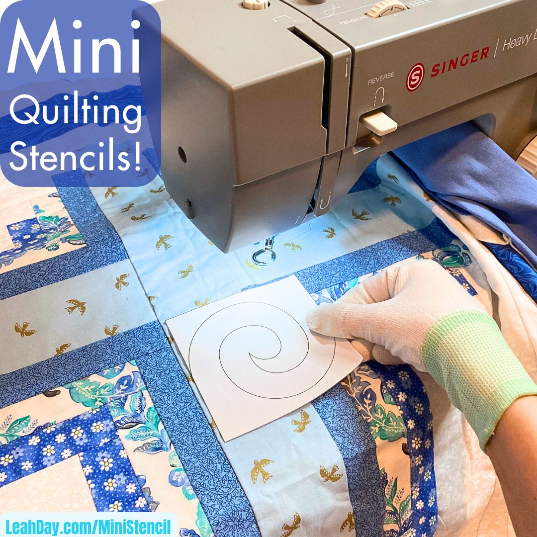 Sewing machine with a quilt and a hand holding a mini quilting stencil.